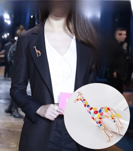 Detail of colorful enamel giraffe brooch pinned on a black suit jacket lapel