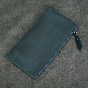 Detail shot of navy blue crazy horse leather wallet showing metal zipper and grain texture