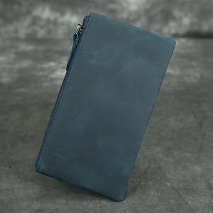 Macro detail of vintage dark green crazy horse leather wallet with premium zipper texture
