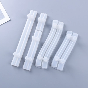 Macro detail of 4-piece translucent silicone resin tray handle molds on grey background