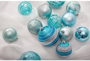 Detail of teal and silver Christmas baubles with glitter snowflake texture on white fabric
