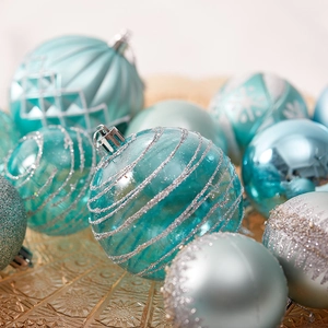 Blue and silver Christmas baubles with various textures on a gold tray decoration