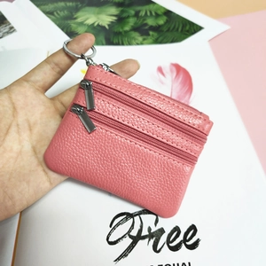 Macro view of pink pebble leather coin purse with triple zippers and metal keyring