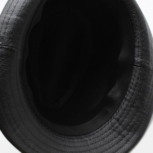 Detail view of the black PU leather hat texture and its inner woven fabric lining