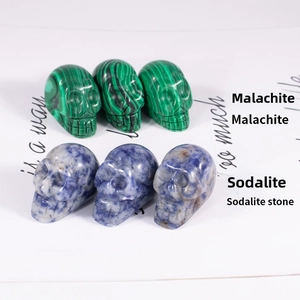 Detailed view of hand-carved skulls in natural green malachite and blue sodalite stones