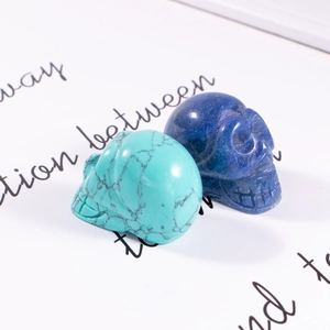Detailed macro view of turquoise and lapis blue hand-carved crystal skull figurines