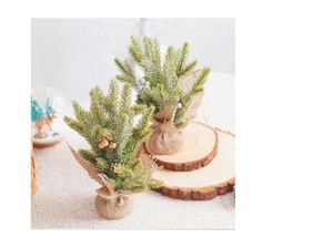 Mini sapin de Noël avec boules dorées sur une base en tranche de bois naturel