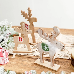 Three wooden Christmas reindeer figurines with bells on a festive tabletop decoration