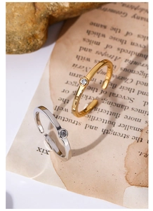 Dettaglio macro di anelli regolabili in oro e argento con zircone su carta vintage