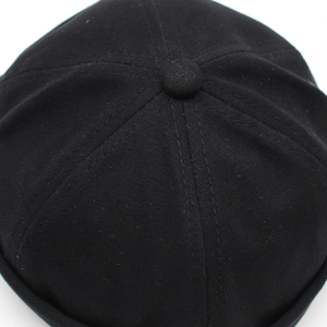 Top view of black cotton docker cap showing six-panel stitching and central fabric button