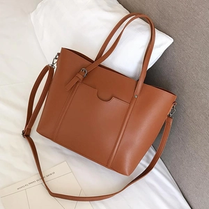 Detail of caramel faux leather tote bag with wavy pocket detail and adjustable strap