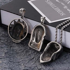 Macro detail of vintage-style stainless steel skull pendants with aged silver finish