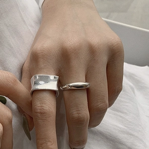 Vintage irregular wide surface and square silver metal rings shown on a hand
