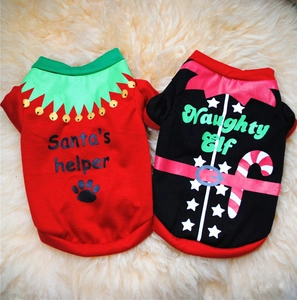 Flat lay of red and black Christmas dog t-shirts with festive prints on white plush rug
