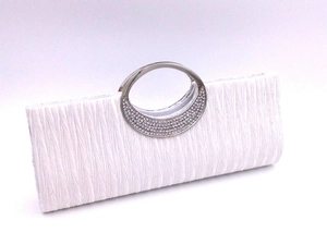 Close-up of elegant pleated white evening clutch with rhinestone silver metal handle
