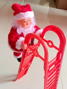 Closer view of electric climbing Santa Claus toy on a red plastic ladder for Christmas
