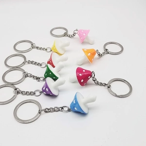Close-up of colorful resin mushroom keychains in eight vibrant shades with white polka dots
