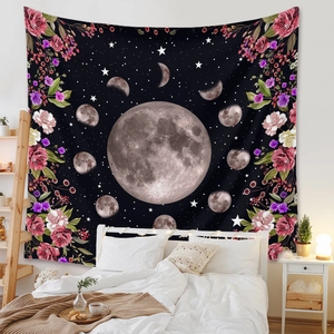 Detail of bohemian moon phase tapestry with floral patterns over a cozy bedroom bed