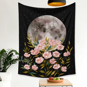 Detail of bohemian moon phase tapestry with pink flowers and gold leaves on a black background