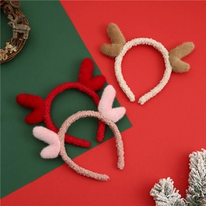 Close-up of three plush reindeer antler headbands in beige red and pink for Christmas