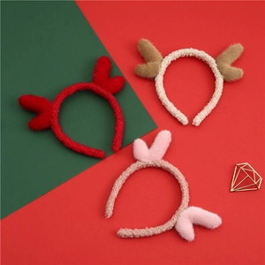Detailed view of three plush reindeer antler headbands in red, beige and pink soft fleece