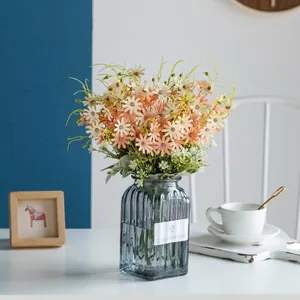 Artificial pink daisy bouquet in blue ribbed glass vase for home decor