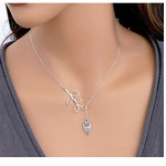 Close-up of silver hollow heart and leaf pendant necklace worn on model neck