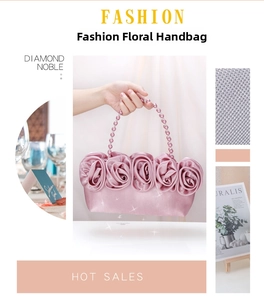 Dettaglio borsa da sera in raso rosa con rose 3D e manico ad anello perlato