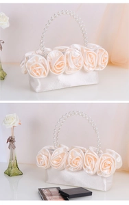Dettaglio borsa a mano in raso crema con rose in tessuto 3D e manico di perle