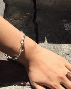 Detail of the 925 sterling silver knotted bracelet on wrist with minimalist design