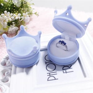 Light blue crown shaped velvet ring jewelry box with flower and frame background