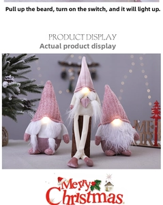 Close-up of glowing pink Christmas gnome plush dolls with knit hats and warm LED lights
