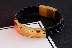 Close-up of black braided leather bracelet with hammered gold-plated stainless steel bar