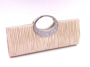 Detail view of champagne pleated evening bag with sparkling rhinestone metal handle