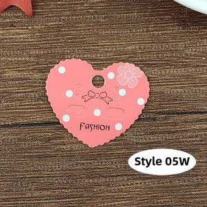 Pink heart-shaped earring display card with scalloped edges and white polka dots pattern