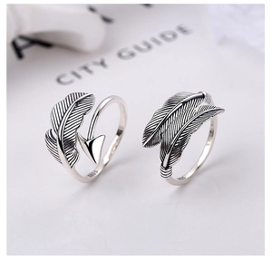 Macro detail of adjustable S925 sterling silver feather and arrow rings in vintage silver