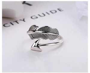 Macro shot of silver feather and arrow adjustable ring with vintage brushed metal texture