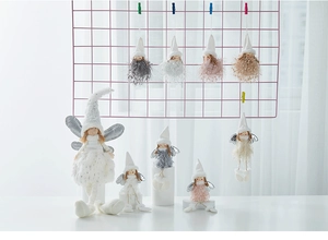 Detail of plush Christmas angel dolls with silver wings and soft feathers for tree decor