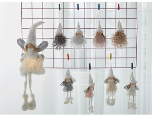 Detail of Christmas plush angel pendants with sequins and warm lights on a pink grid