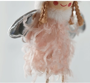 Macro shot of pink plush angel doll with feather skirt and silver wings detail