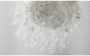 Macro shot of white plush angel pendant with mesh texture and soft fringe details