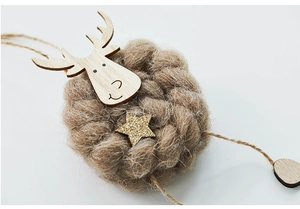 Macro detail of wool felt reindeer ornament with wooden head and gold star decor