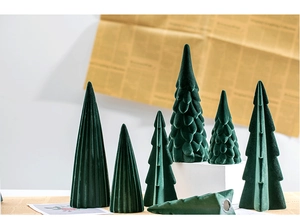 Detail of assorted green flocked ceramic Christmas trees on a white countertop
