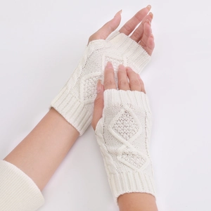 Detailed close-up of white knit fingerless gloves with elegant diamond pattern texture