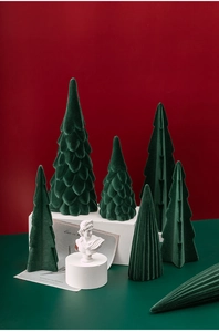 Close-up of dark green flocked ceramic Christmas trees with velvet texture on stands