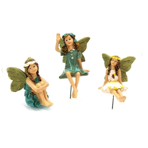 Close-up of resin flower fairy figurines in green and white dresses for garden decor
