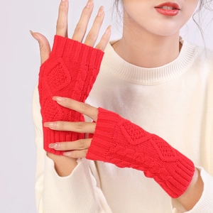 Detail of red cable knit fingerless gloves showing thick texture and wool pattern