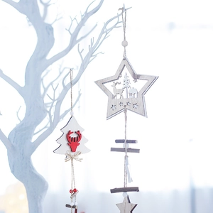 Nordic wooden Christmas ornaments with reindeer and tree designs hanging on a branch