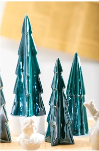 Close-up of dark green ceramic Christmas tree decor set with high gloss glazed finish
