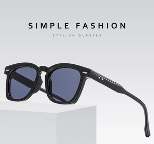 Detail view of black thick-frame sunglasses with gold star accents and blue lenses